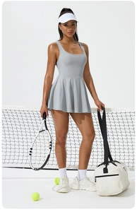 Detail view of a pleated athletic tennis dress with a racerback and mesh tennis bag