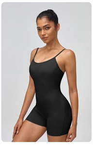 Close-up of black one-piece yoga romper with U-neck and back tie detail on model