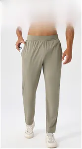 Detail view of men's quick-dry sports trousers featuring olive green fabric and functional pocket
