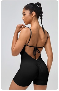 Detailed back view of a black one-piece yoga jumpsuit with criss-cross back tie and scrunch butt