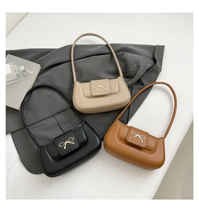 Detail shot of elegant bow metal buckles on three solid color minimalist shoulder bags