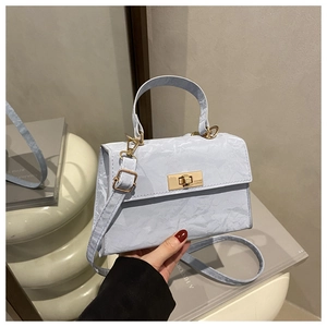 Detail of light blue crossbody bag featuring marble texture leather and golden turn lock