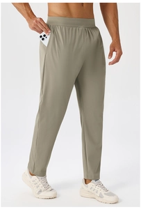 Detail view of khaki quick-dry athletic pants showing deep pocket with a mobile phone