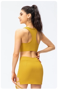 Detail of mustard yellow ribbed racerback sports top and side-tie mini skirt set