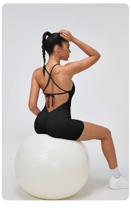 Close-up of black backless yoga bodysuit with cross-straps and scrunch butt detail