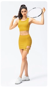Detail of yellow ribbed tennis set featuring a racerback tank top and crisscross skirt