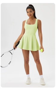 Detail of light green tennis dress featuring U-neckline, racerback and pleated hemline