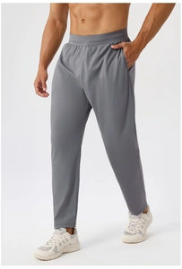 Detail of grey men's sports pants featuring an elastic waistband and quick-dry fabric