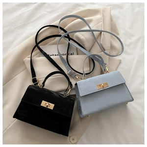 Detail of elegant black and blue leather crossbody bags with gold metal handles on blazers