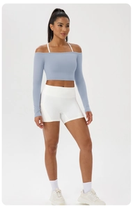 Détail du haut de yoga bleu clair épaules dénudées avec bretelles blanches et short taille haute