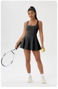 Detail view of moisture-wicking black tennis dress with pleated skirt and slimming waist