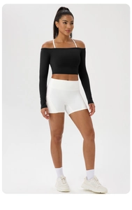 Détail du haut de yoga noir à épaules dénudées avec bretelles blanches et short taille haute