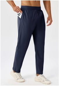 Detail of side pocket on men's quick-dry sports pants showing depth with a smartphone