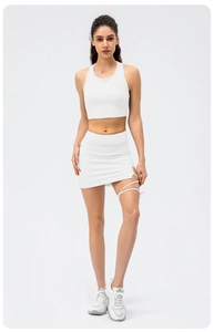 Close-up of white ribbed yoga crop top and matching mini skirt with side strap detail