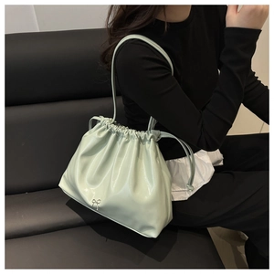 Détail du sac froncé vert menthe avec cordon de serrage et décoration nœud argenté