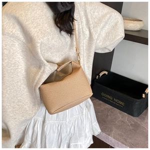 Détail du sac bandoulière tissé marron clair avec boucle en métal et fine sangle