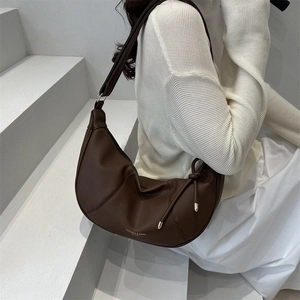Brown leather crescent hobo bag with top zipper and gold knot detail for women