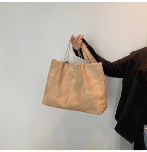 Détail d'un sac cabas kaki avec texture mate et chaîne dorée pour un usage quotidien chic
