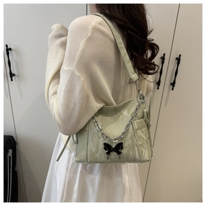 Detail of light green marble texture bag with silver chain and black butterfly charm