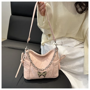 Detail of light pink wrinkled leather bag featuring silver butterfly buckle and chain strap