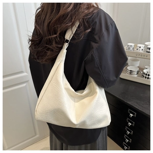 Detail of cream white oversized tote bag with wrinkled leather texture and wide shoulder strap