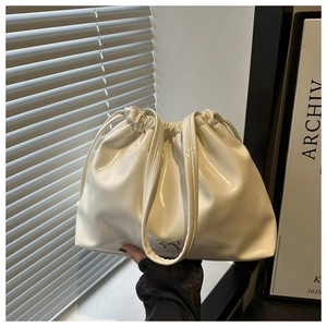 Détail du sac cabas blanc brillant avec cordon et ornement papillon en métal argenté