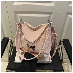 Detail of light pink hobo bag with silver butterfly buckle and metallic chain strap