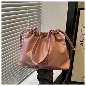 Détail du sac fourre-tout en cuir verni rose clair avec cordon et logo métallique