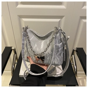 Detail of silver pleated texture on shoulder bag with butterfly charm and chain strap