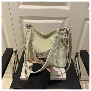 Detail of light green ruched hobo bag with silver butterfly charm and chain strap