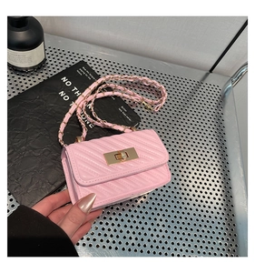 Close-up detail of pink quilted mini crossbody bag with gold metal twist lock and chain