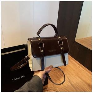 Detailed close-up of retro color-block handbag with gold rivets and FASHION logo