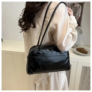 Detail der glänzenden schwarzen Bowling-Tasche aus Leder mit Metallreißverschluss