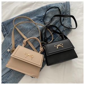 Detail of elegant solid color tote bags with gold bow buckle and knotted handles