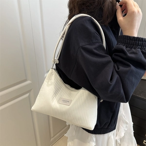 Minimalist beige hobo bag with vertical stripes and high capacity shoulder strap
