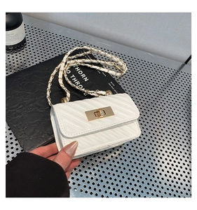 Macro detail of white quilted handbag with golden rectangular twist-lock and chain strap