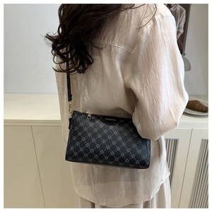 Detail view of the deep gray monogram crossbody bag showing the fashion label and zipper