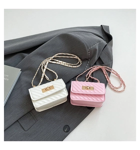 Close-up of V-quilted mini chain bags in pearl white and soft pink with gold hardware