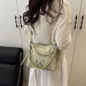Fashionable mint green crossbody bag with ribbon chain and metallic butterfly detail
