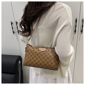 Detail view of a brown crossbody bag with black cross pattern and FASHION leather label