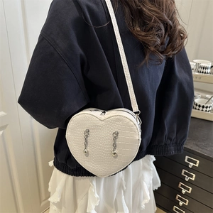 White heart-shaped crossbody bag with crocodile texture and silver chain tassels
