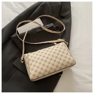 Detail of beige vintage pattern crossbody bag with gold hardware and adjustable strap