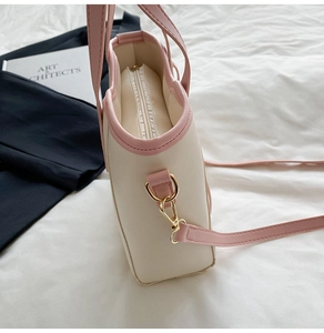 Detail of contrast tote bag featuring beige lychee leather and pink edges with gold hardware