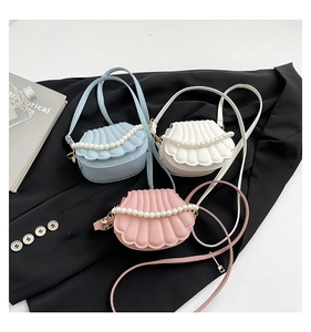 Vue détaillée de sacs en forme de coquillages rose, bleu et blanc ornés de perles élégantes