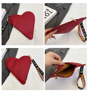 Detailansicht der roten Herz-Lederclutch mit LOVE-Armband und goldener Hardware