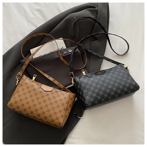 Flat lay of brown and black PU leather crossbody bags with floral monogram and gold zipper