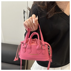 Pink drawstring mini tote bag featuring pebbled leather texture and gold lettering