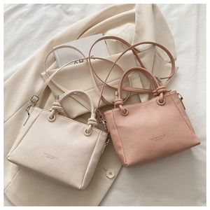 Close-up of litchi grain leather texture and knot detail on stylish bucket bags