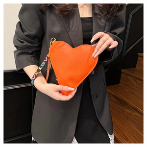 Makroaufnahme der orangefarbenen Herz-Lederhandtasche mit LOVE-Regenbogen-Handschlaufe