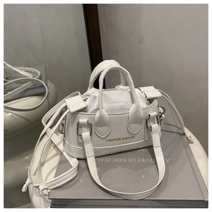 Close-up of white lychee pattern handbag featuring drawstring and gold fashion logo
